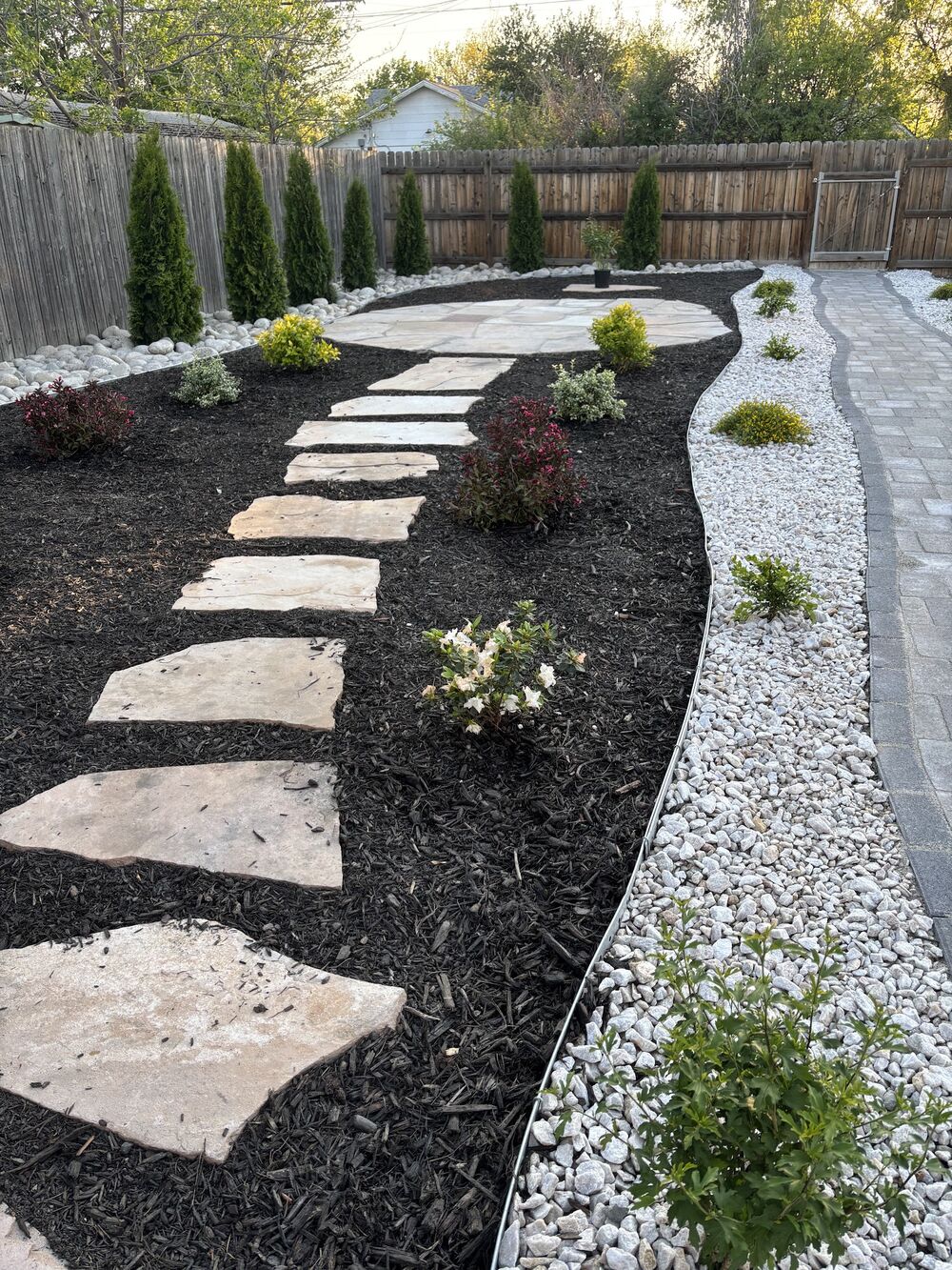 Flagstone stepping path with black mulch and white rock border